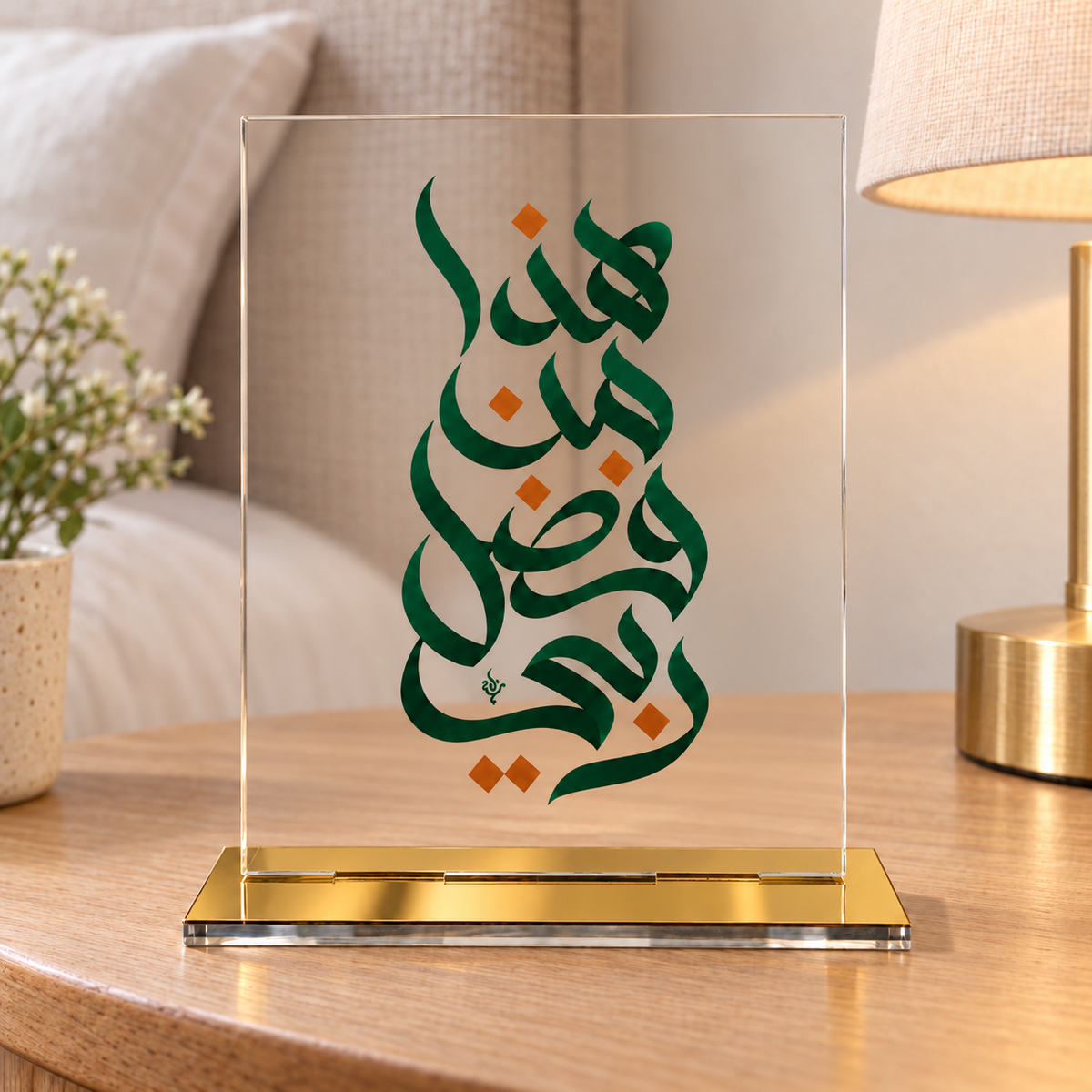 Islamic Arabic calligraphy plaque with dark green lettering, orange geometric accents, clear panel and gold-tone tabletop base